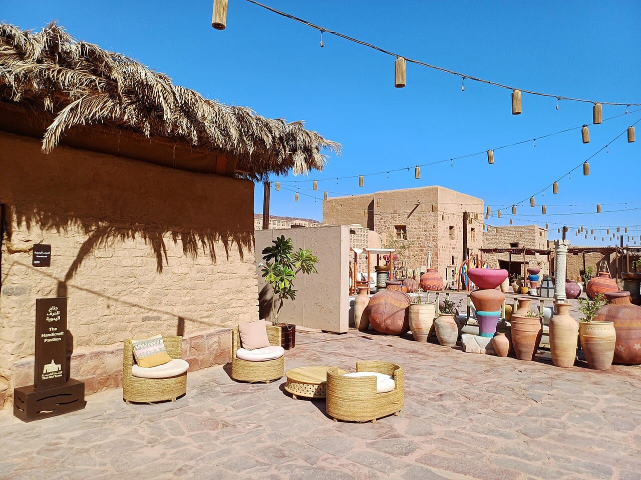 Cafe seating and pottery along a restored street by AlUla Old Town