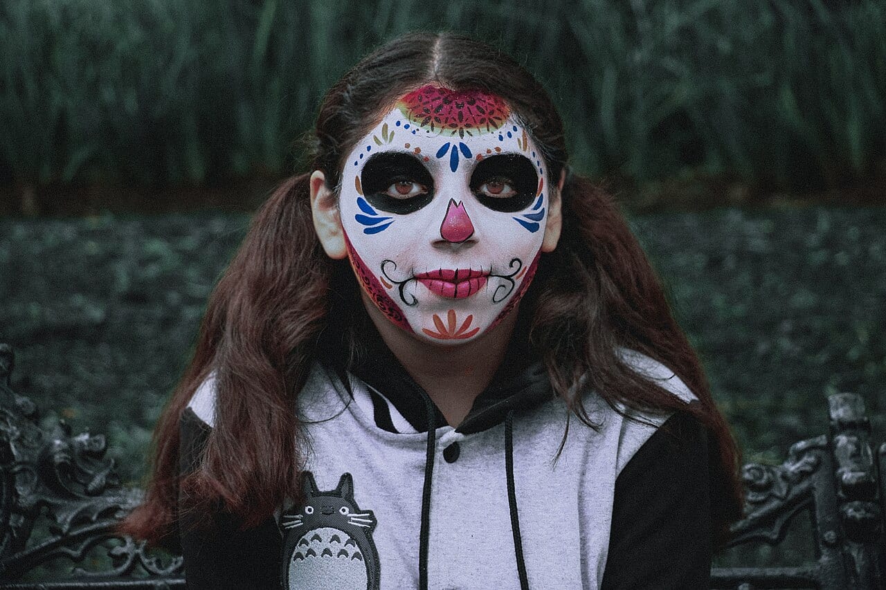 A young woman in Catrina face paint and costume in the Day of the Dead parade in Mexico City historic centre