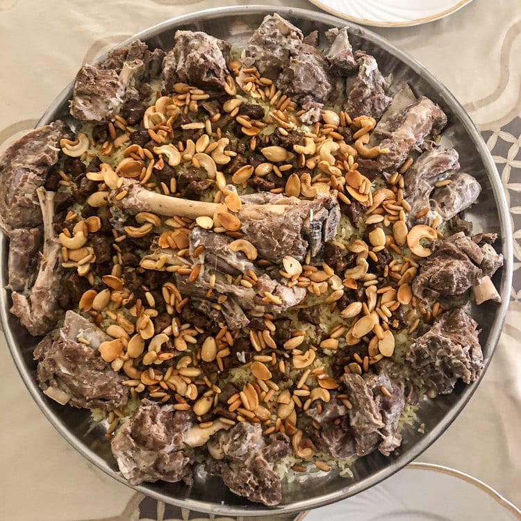 A platter of mansaf: lamb on rice and shrak bread with jameed sauce and nuts