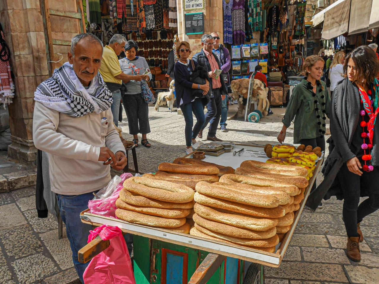 A street seller with a cart piled with long sesame ka'ak bread