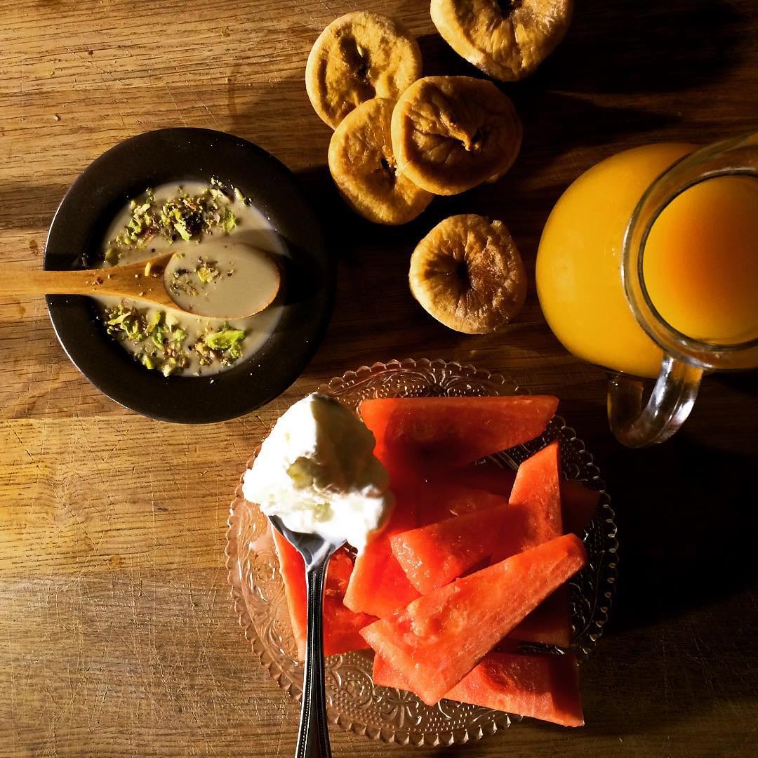 A Jordanian suhur table with dates, fruit, juice and small breads