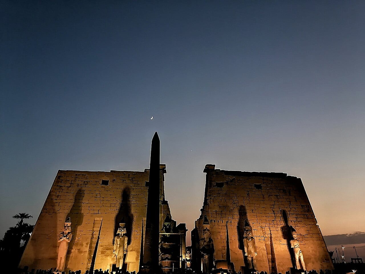The lit pylon and obelisk of Luxor Temple at night