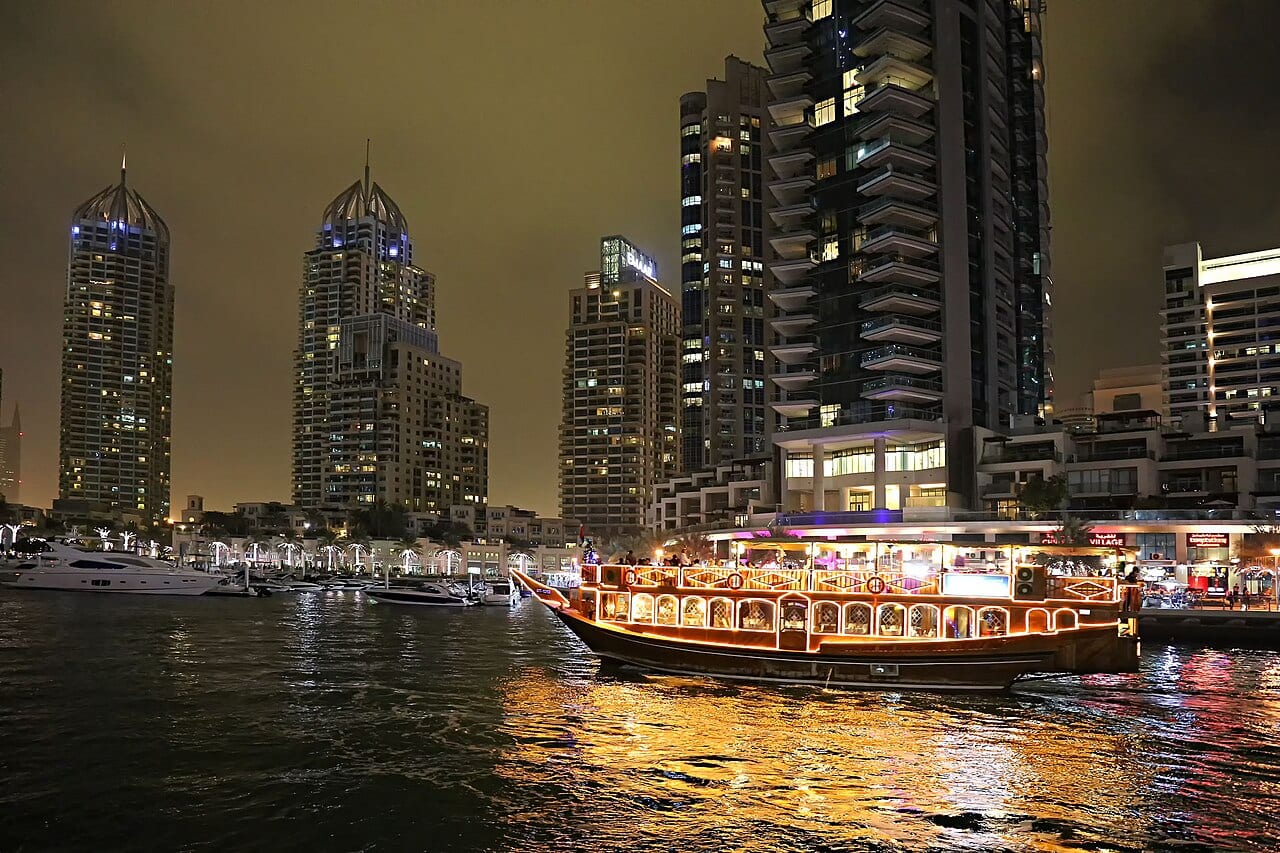 Dubai Marina towers reflected in the water at night