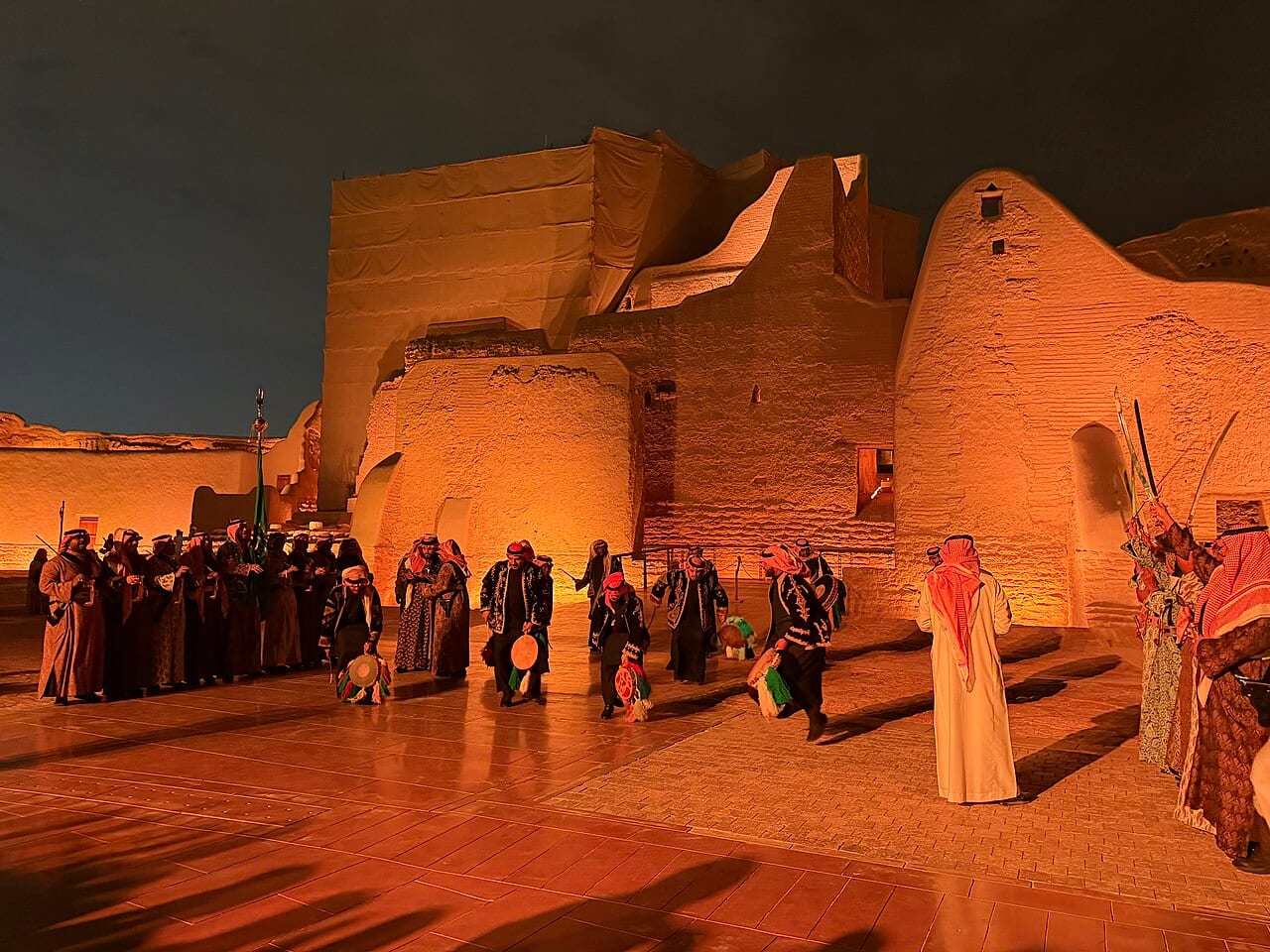 The mud-brick walls of At-Turaif in Diriyah at dusk with visitors