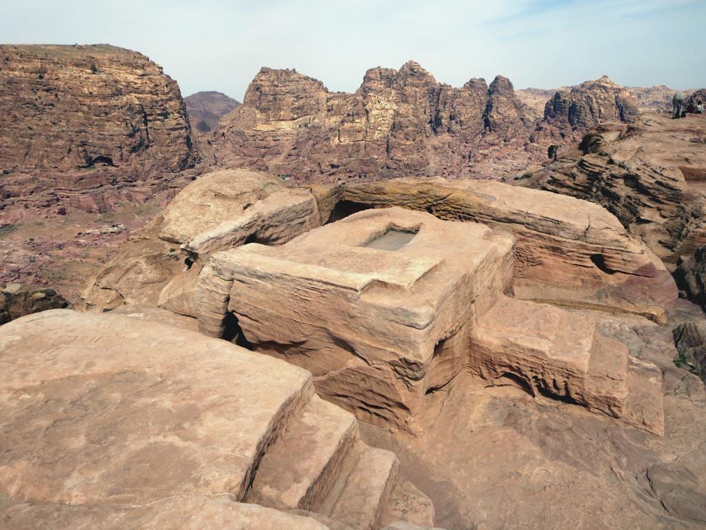 The rock-cut altar of the High Place of Sacrifice above Petra with mountains behind