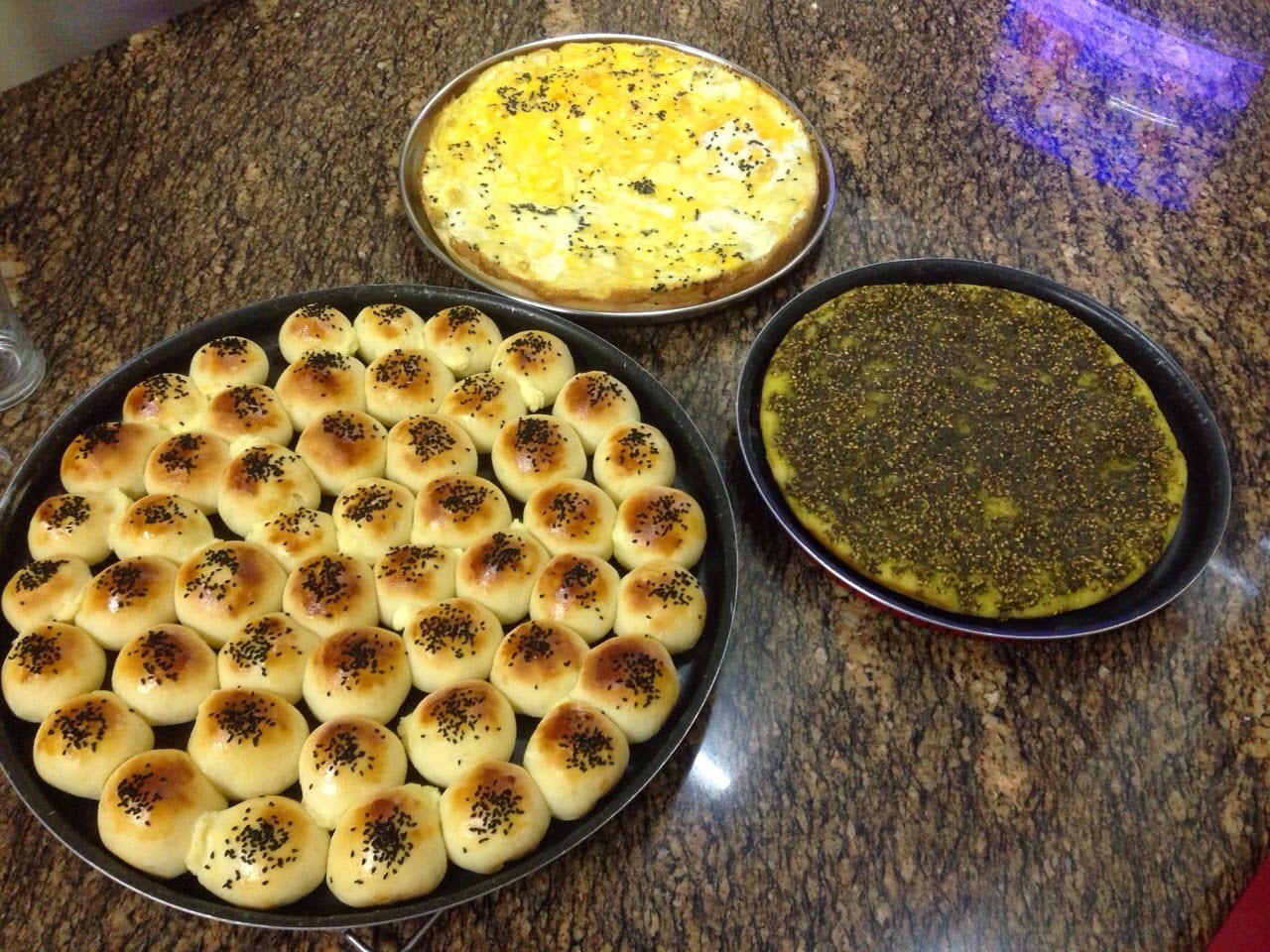 Trays of manakish with za'atar, cheese and egg fresh from a Jordanian oven