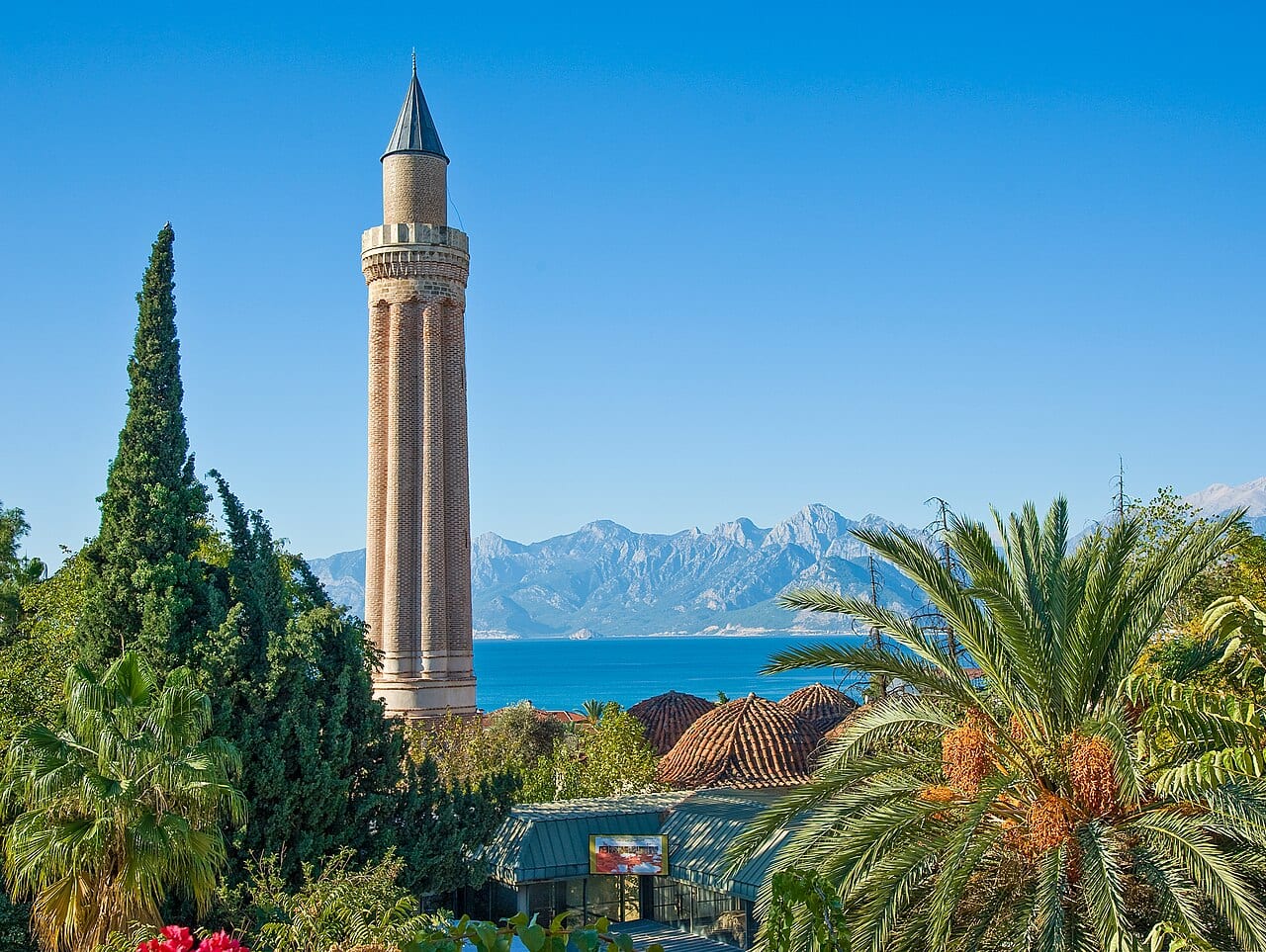 The Yivli Minare and the old town roofs of Antalya with mountains behind