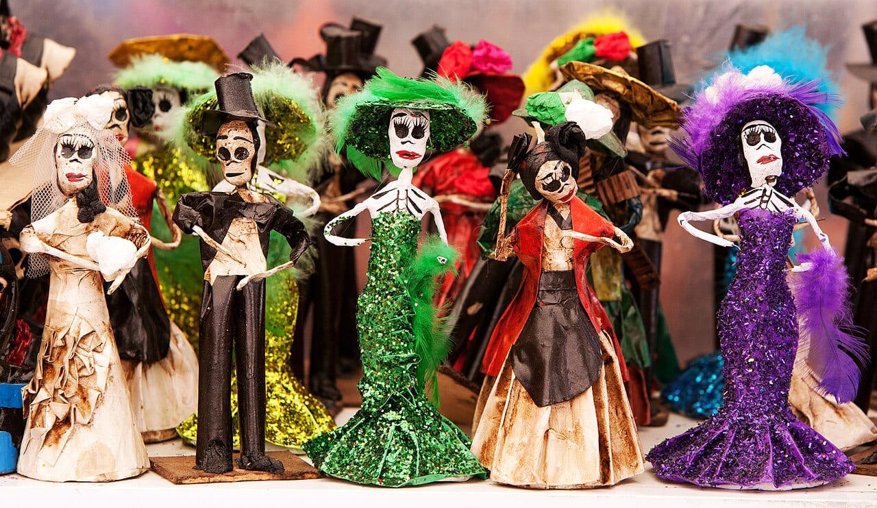 Catrina skeleton figures in traditional dress at a Day of the Dead celebration in Mexico