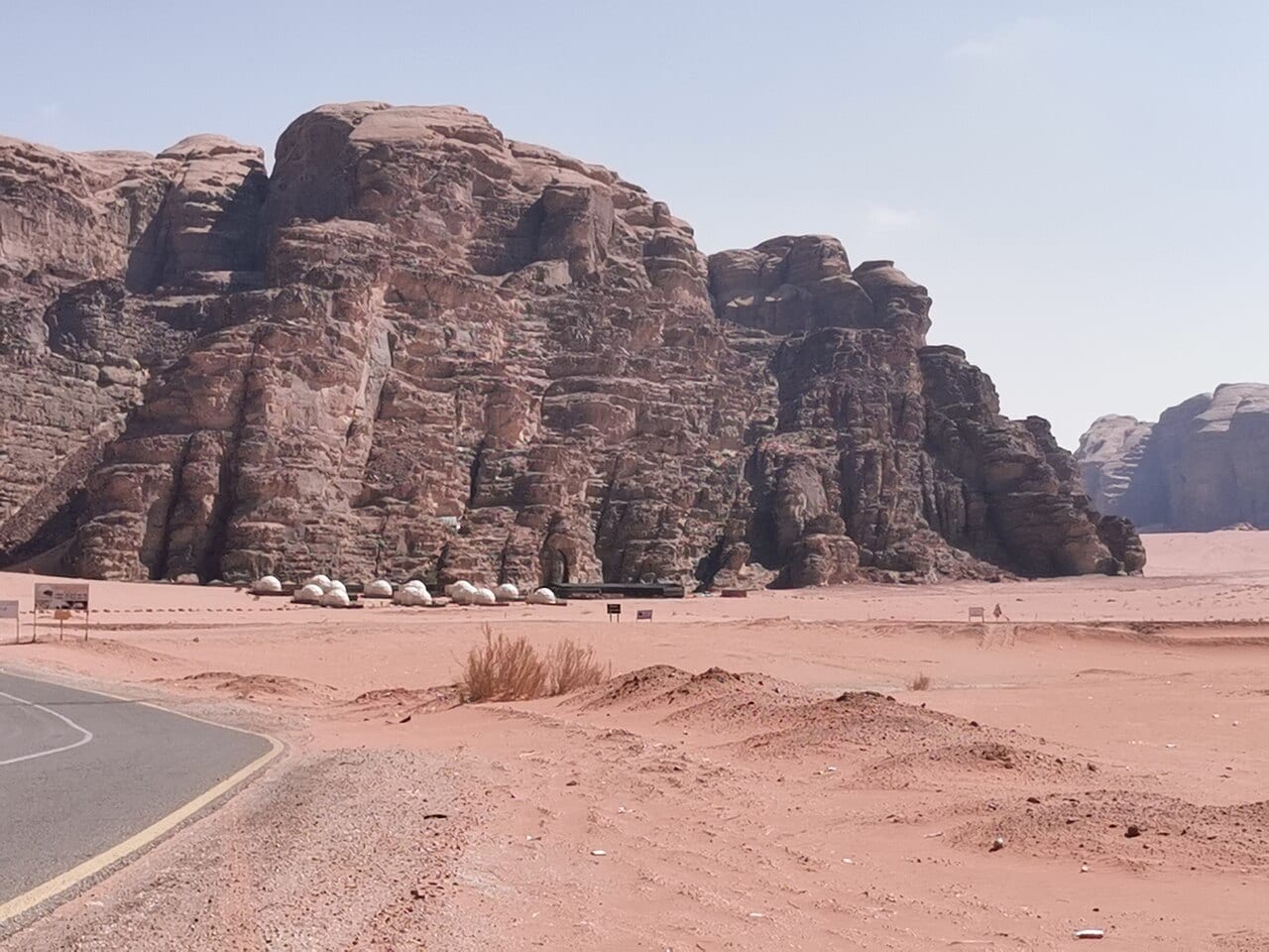 Bedouin tents and dome tents of a desert camp under the cliffs of Wadi Rum